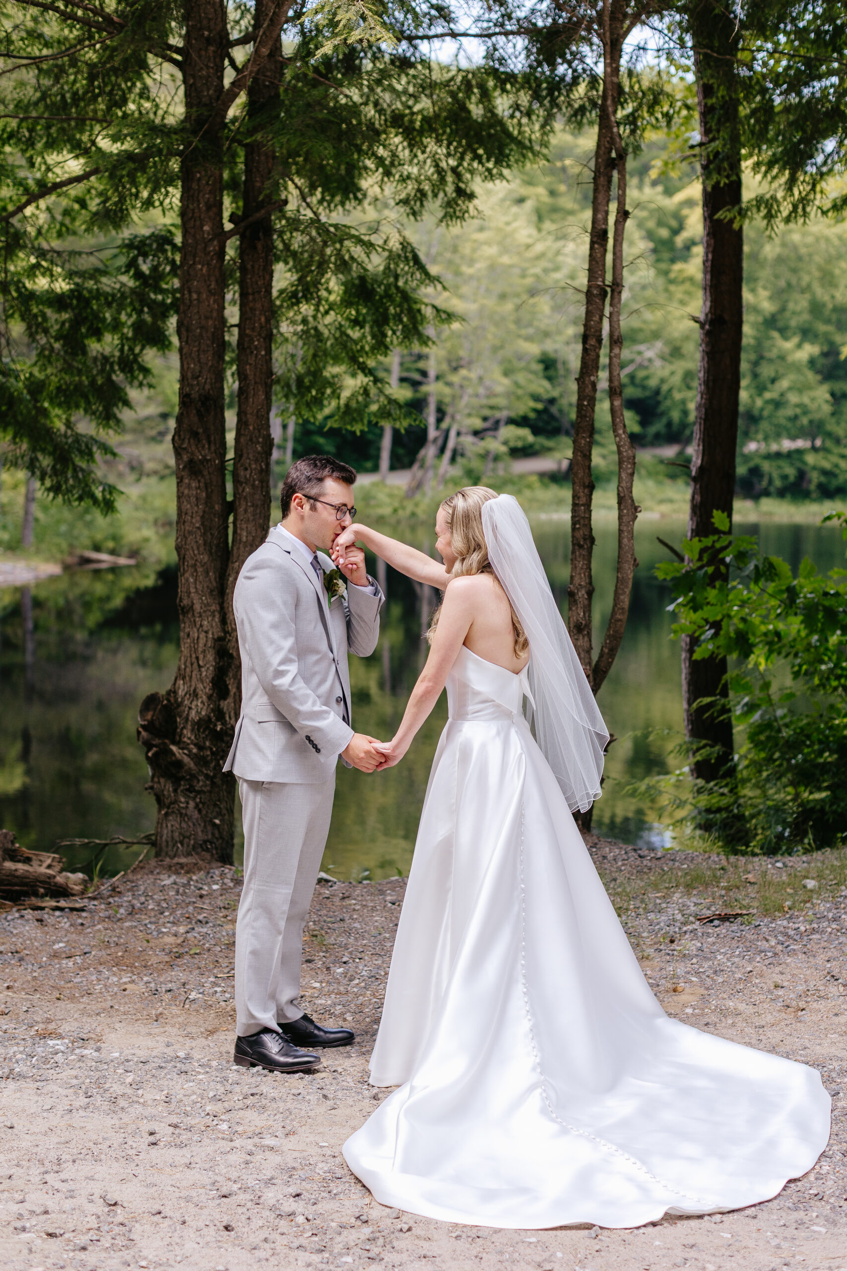 Groom kisses bride at first look lakeside at their Muskoka wedding.
